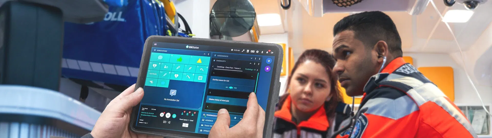 Emergency medical personnel using tablet to monitor patient data inside ambulance equipped with modern medical devices.