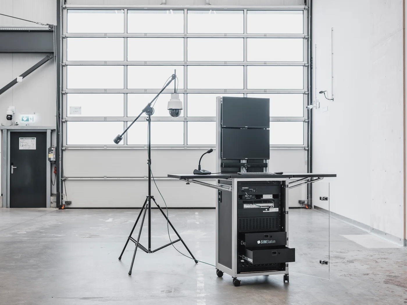 A portable, all-in-one mobile simulation unit featuring integrated monitors, rack-mounted hardware, and an adjustable camera stand for in-situ training.