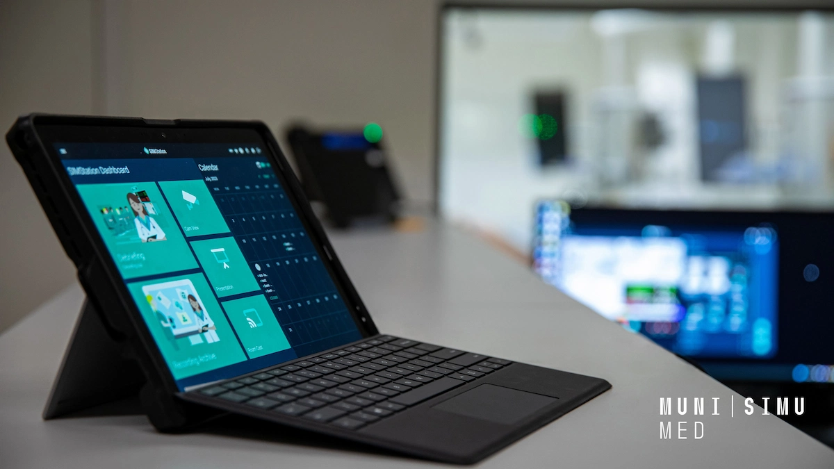 A close-up of a tablet with a keyboard case displaying the SIMStation dashboard at MUNI SIMU MED, showing scheduling and recording management tools for medical simulation training.