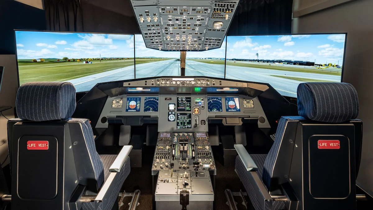 A modern airplane cockpit simulator with two pilot seats, detailed control panels, and three large screens displaying a runway and sky—ideal for flight simulator team training in Vienna, simulating an authentic takeoff view.